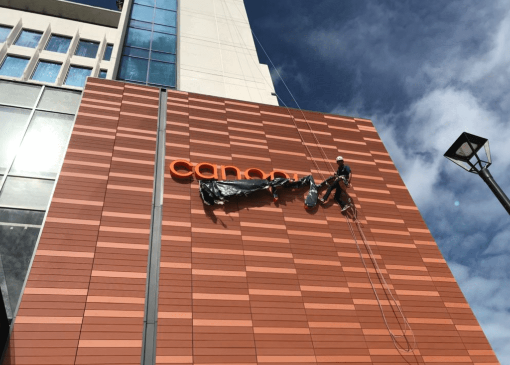 Técnicos verticales colocando un letrero